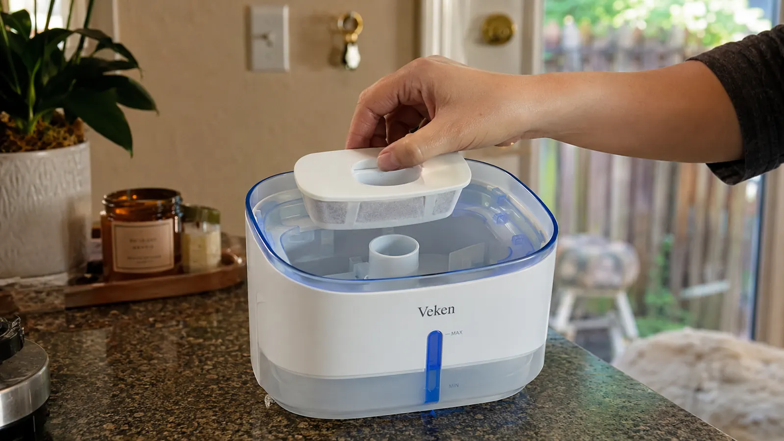 Hand assembling the filter cartridge into a Veken pet water fountain before filling it with water